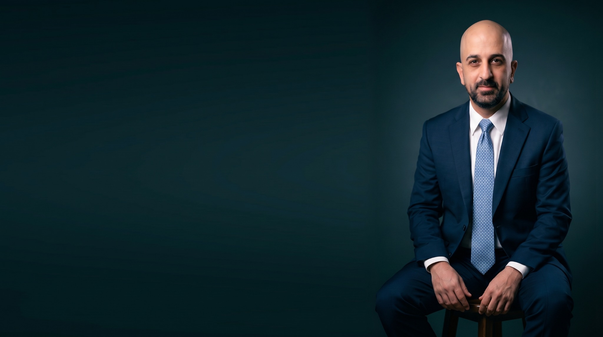 Waleed Albaddad, seated in a navy suit